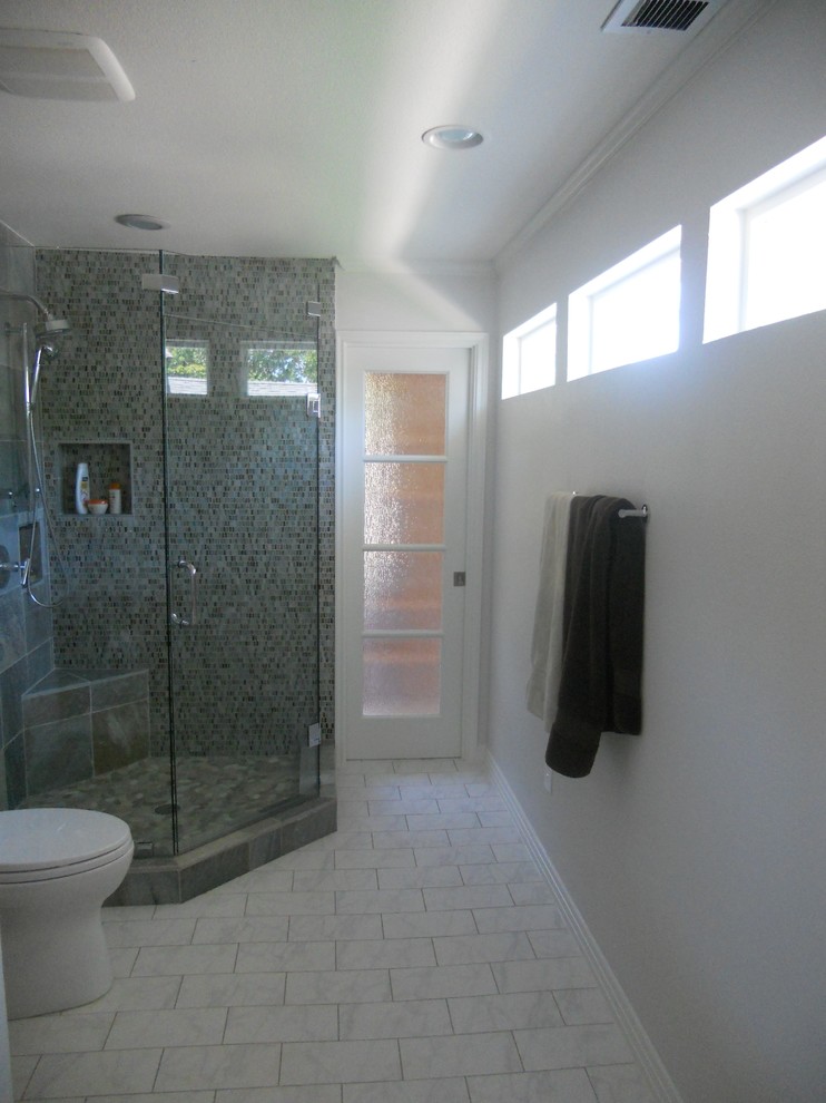 Ispirazione per una stanza da bagno minimal con ante lisce, ante in legno chiaro, top in marmo, doccia ad angolo, piastrelle multicolore e piastrelle in pietra