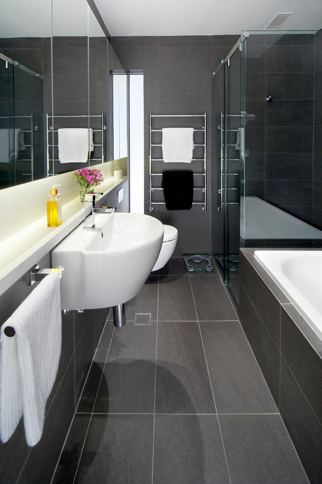 Kleines Modernes Duschbad mit schwarzen Fliesen, Einbaubadewanne, Eckdusche, Toilette mit Aufsatzspülkasten, Porzellanfliesen, grauer Wandfarbe, Porzellan-Bodenfliesen, Wandwaschbecken und grauem Boden in Sydney