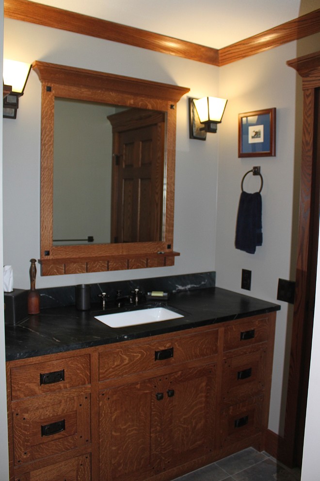 Foto di una stanza da bagno con doccia american style di medie dimensioni con ante in stile shaker, ante in legno scuro, doccia alcova, piastrelle grigie, piastrelle di ciottoli, pareti beige e lavabo sottopiano