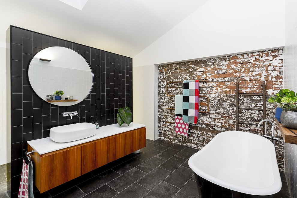 Exempel på ett stort industriellt badrum, med ett badkar med tassar, en dusch i en alkov, svart kakel, keramikplattor, vita väggar, klinkergolv i keramik, marmorbänkskiva, grått golv, med dusch som är öppen och släta luckor