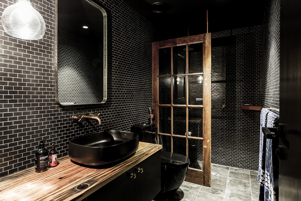 Idéer för ett stort industriellt badrum, med en hörndusch, en toalettstol med hel cisternkåpa, svart kakel, keramikplattor, svarta väggar, klinkergolv i keramik, marmorbänkskiva, grått golv och med dusch som är öppen