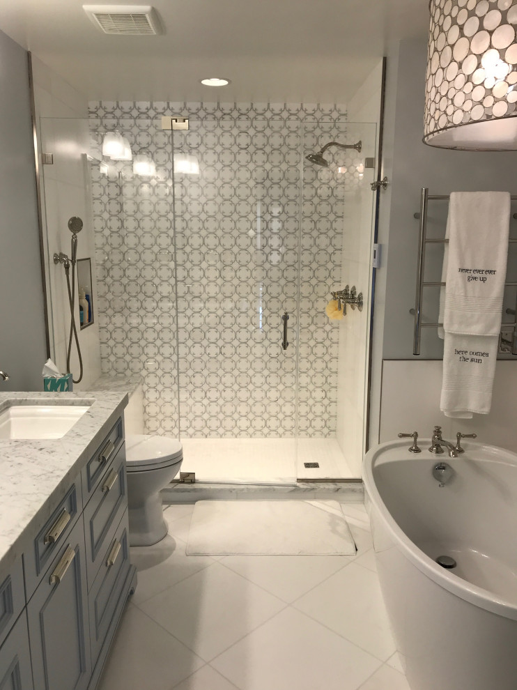 Источник вдохновения для домашнего уюта: ванная комната в стиле неоклассика (современная классика) с плоскими фасадами, синими фасадами, отдельно стоящей ванной, душем в нише, унитазом-моноблоком, белой плиткой, мраморной плиткой, синими стенами, мраморным полом, врезной раковиной, мраморной столешницей, белым полом, душем с распашными дверями, сиденьем для душа и тумбой под две раковины