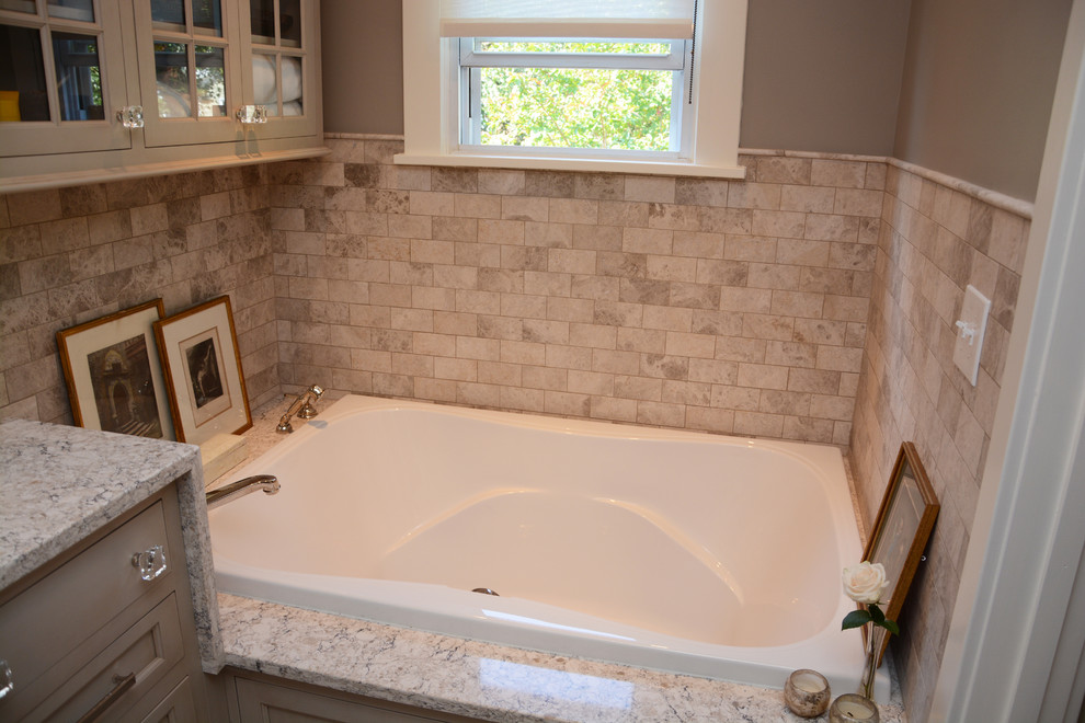 Photo of a medium sized farmhouse ensuite bathroom in Baltimore with recessed-panel cabinets, beige cabinets, a hot tub, a corner shower, beige tiles, a submerged sink and engineered stone worktops.