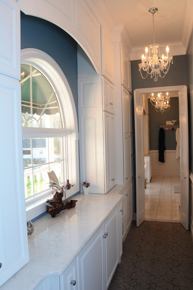 Klassisk inredning av ett stort vit vitt en-suite badrum, med luckor med upphöjd panel, vita skåp, ett badkar i en alkov, en hörndusch, en toalettstol med separat cisternkåpa, vit kakel, blå väggar, ett undermonterad handfat, bänkskiva i kvarts, vitt golv och dusch med gångjärnsdörr