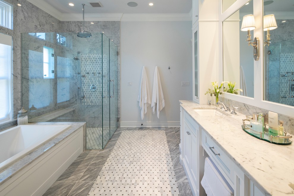 На фото: главная ванная комната с фасадами с утопленной филенкой, белыми фасадами, накладной ванной, угловым душем, серой плиткой, серыми стенами, врезной раковиной, серым полом, душем с распашными дверями и белой столешницей с