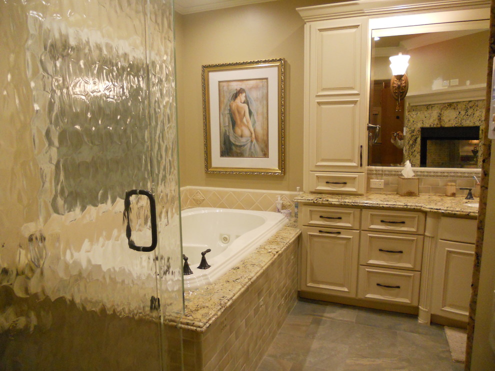 Large elegant master beige tile and ceramic tile slate floor and gray floor bathroom photo in San Francisco with raised-panel cabinets, beige cabinets, beige walls, an undermount sink, granite countertops, a hinged shower door and beige countertops