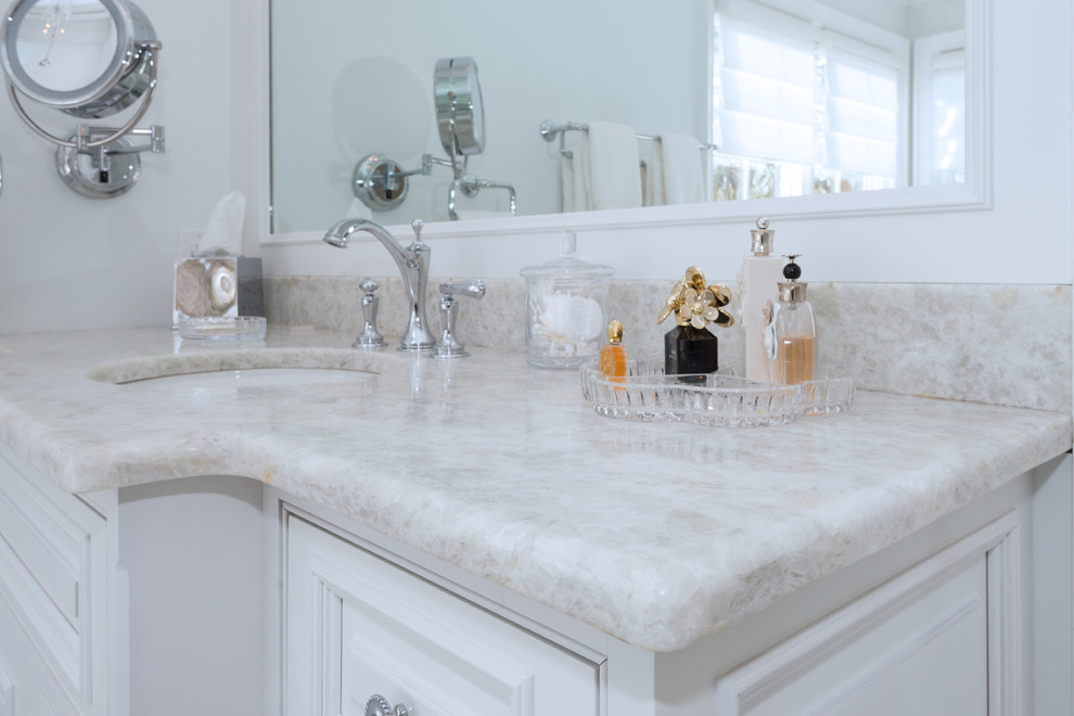 Imagen de cuarto de baño principal, actual, grande, con lavabo bajoencimera, encimera de cuarcita, armarios con paneles con relieve, puertas de armario blancas, bañera exenta, ducha esquinera, baldosas y/o azulejos blancos, baldosas y/o azulejos de piedra, suelo de mármol y suelo gris