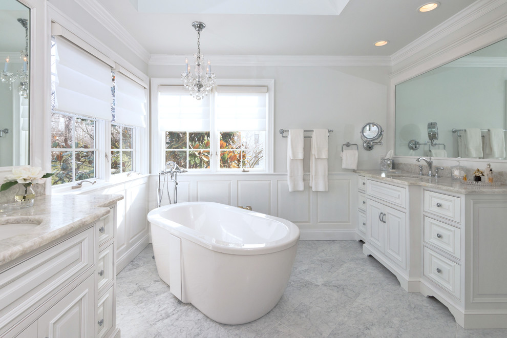 Источник вдохновения для домашнего уюта: большая главная ванная комната в классическом стиле с отдельно стоящей ванной, белой плиткой, каменной плиткой, мраморным полом, врезной раковиной, фасадами с выступающей филенкой, белыми фасадами, серыми стенами, серым полом, угловым душем, столешницей из кварцита и душем с распашными дверями