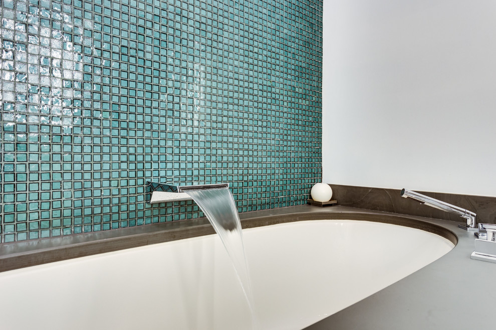 Modern inredning av ett mellanstort grå grått en-suite badrum, med släta luckor, vita skåp, ett undermonterat badkar, en kantlös dusch, en bidé, grön kakel, glaskakel, vita väggar, skiffergolv och bänkskiva i täljsten
