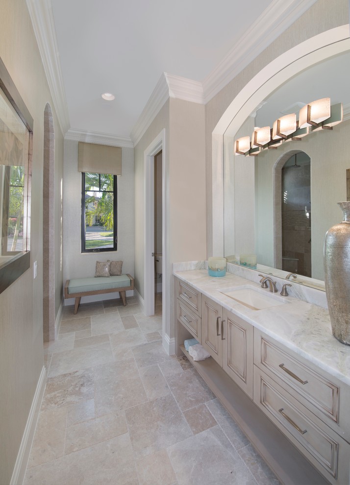 Photo of a large mediterranean ensuite bathroom in Miami with recessed-panel cabinets, beige cabinets, a built-in bath, a corner shower, multi-coloured walls, travertine flooring, a submerged sink, marble worktops and beige floors.