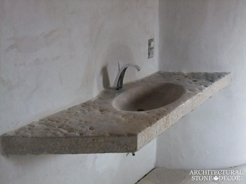 Immagine di una stanza da bagno padronale mediterranea con lavabo sospeso e top in pietra calcarea