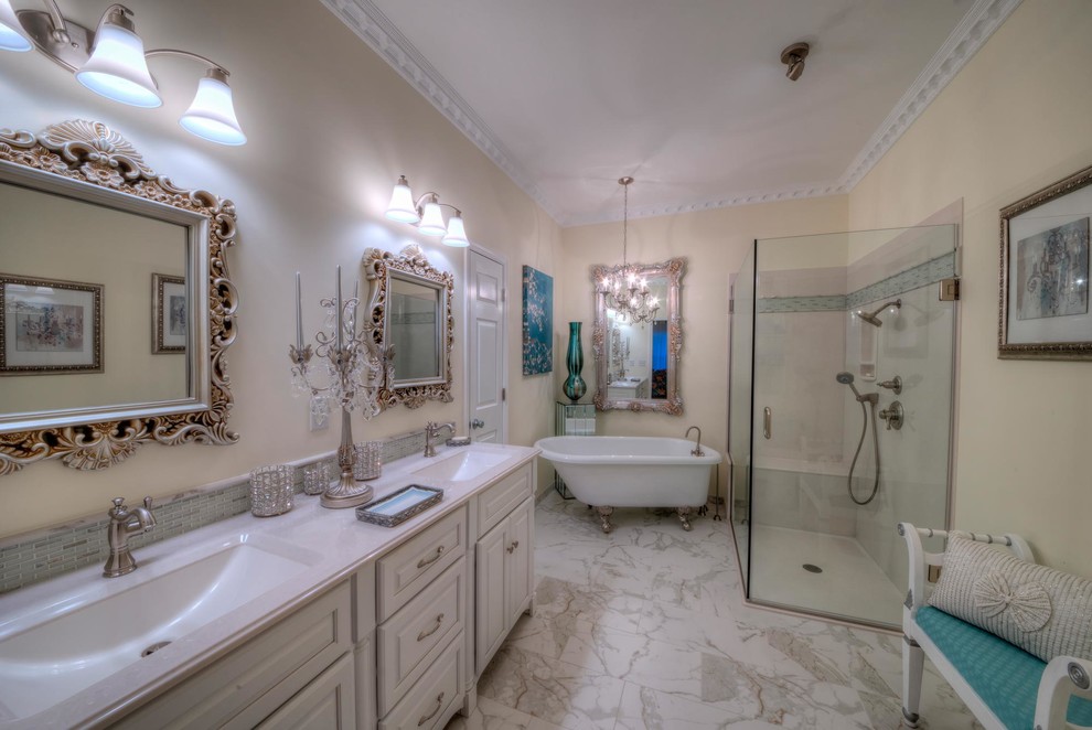 Inspiration for a large timeless master porcelain tile and multicolored floor bathroom remodel in St Louis with raised-panel cabinets, white cabinets, yellow walls, an integrated sink, onyx countertops, a hinged shower door and a two-piece toilet