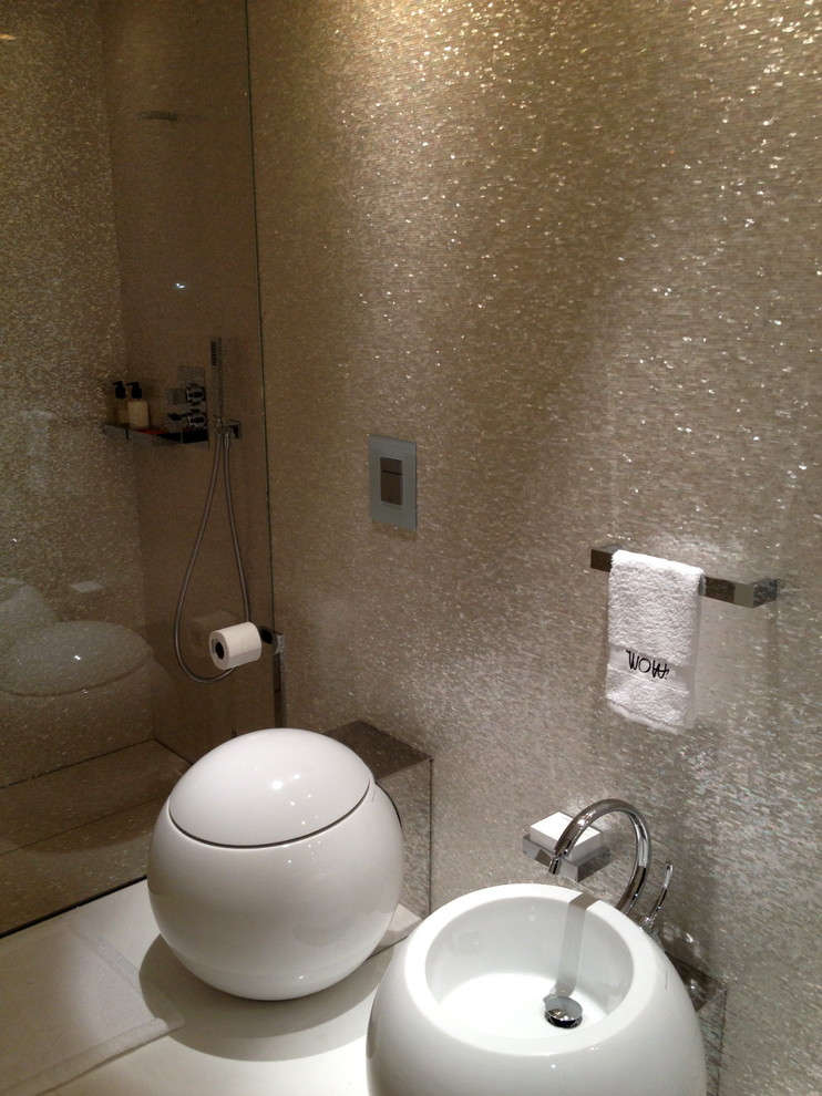 Источник вдохновения для домашнего уюта: туалет среднего размера в современном стиле с раздельным унитазом, бежевой плиткой, стеклянной плиткой, бежевыми стенами, полом из керамогранита и настольной раковиной