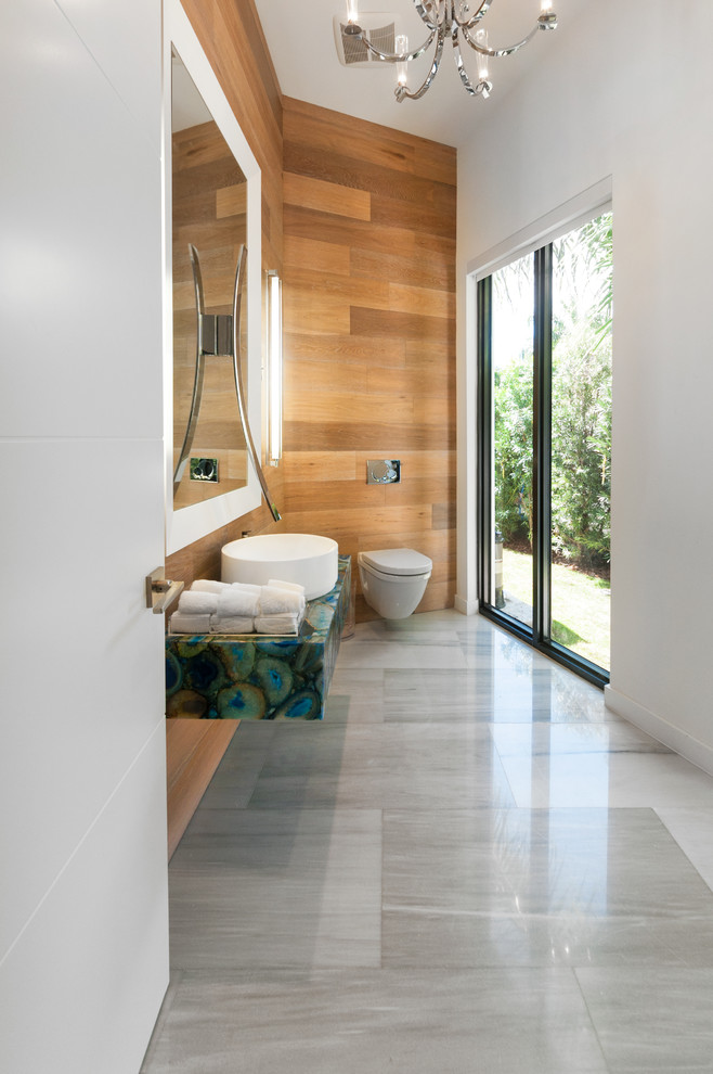 マイアミにあるコンテンポラリースタイルのおしゃれな浴室 (壁付け型シンク、大理石の洗面台、壁掛け式トイレ、白い壁、大理石の床) の写真