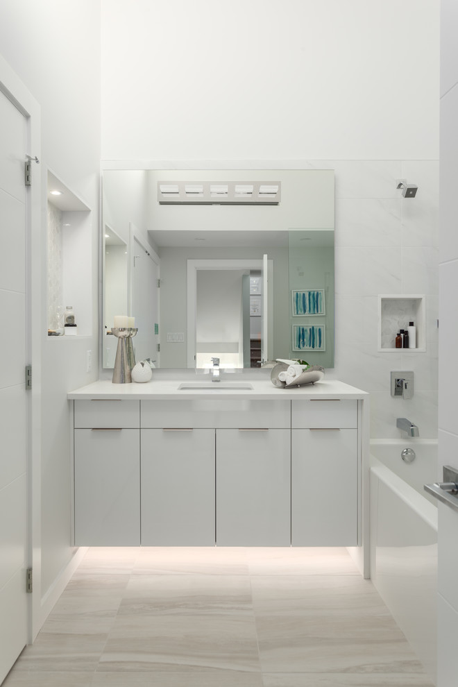 Inspiration for a medium sized modern bathroom in Vancouver with freestanding cabinets, white cabinets, a built-in bath, ceramic tiles, quartz worktops, a hinged door, a one-piece toilet, white tiles, white walls, porcelain flooring, a submerged sink, beige floors and white worktops.