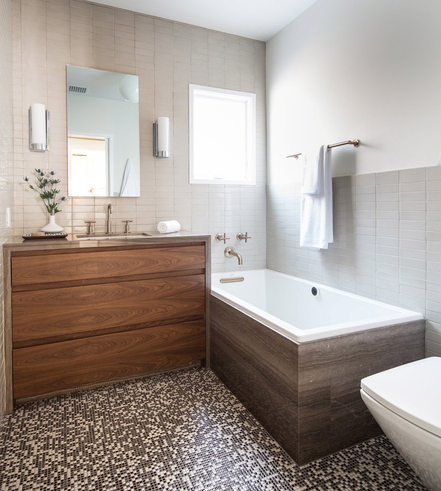 ロサンゼルスにあるトランジショナルスタイルのおしゃれな浴室 (フラットパネル扉のキャビネット、中間色木目調キャビネット、アルコーブ型浴槽、グレーのタイル、アンダーカウンター洗面器) の写真