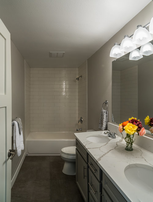 Inspiration for a large timeless master white tile and subway tile concrete floor and brown floor bathroom remodel in Seattle with recessed-panel cabinets, gray cabinets, a two-piece toilet, gray walls, an undermount sink and quartzite countertops