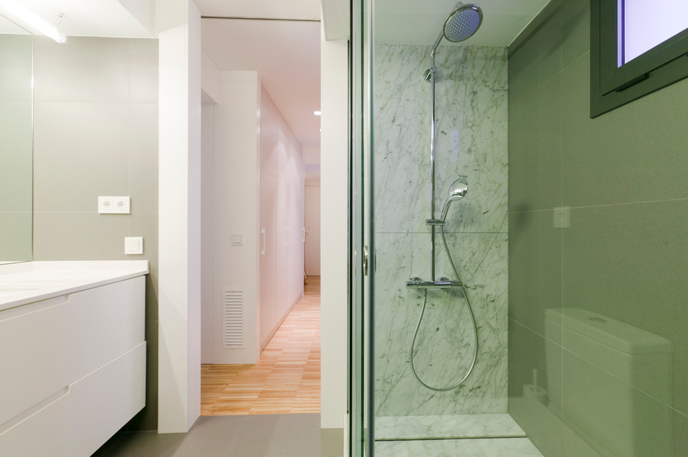 Imagen de cuarto de baño actual de tamaño medio con armarios con paneles lisos, puertas de armario blancas, ducha empotrada, aseo y ducha y lavabo integrado