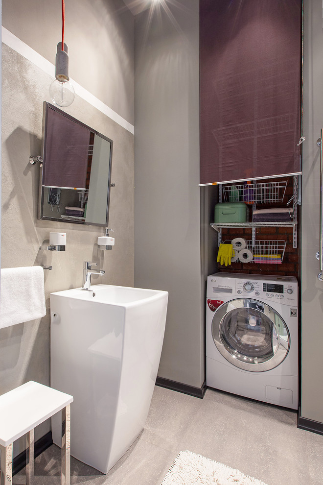 На фото: ванная комната со стиральной машиной в стиле лофт с бежевой плиткой, серыми стенами и раковиной с пьедесталом с