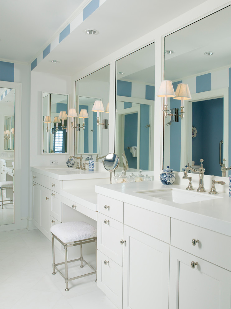 Imagen de cuarto de baño principal tradicional de tamaño medio con armarios estilo shaker, puertas de armario blancas, paredes blancas, suelo de mármol, lavabo bajoencimera y encimera de acrílico