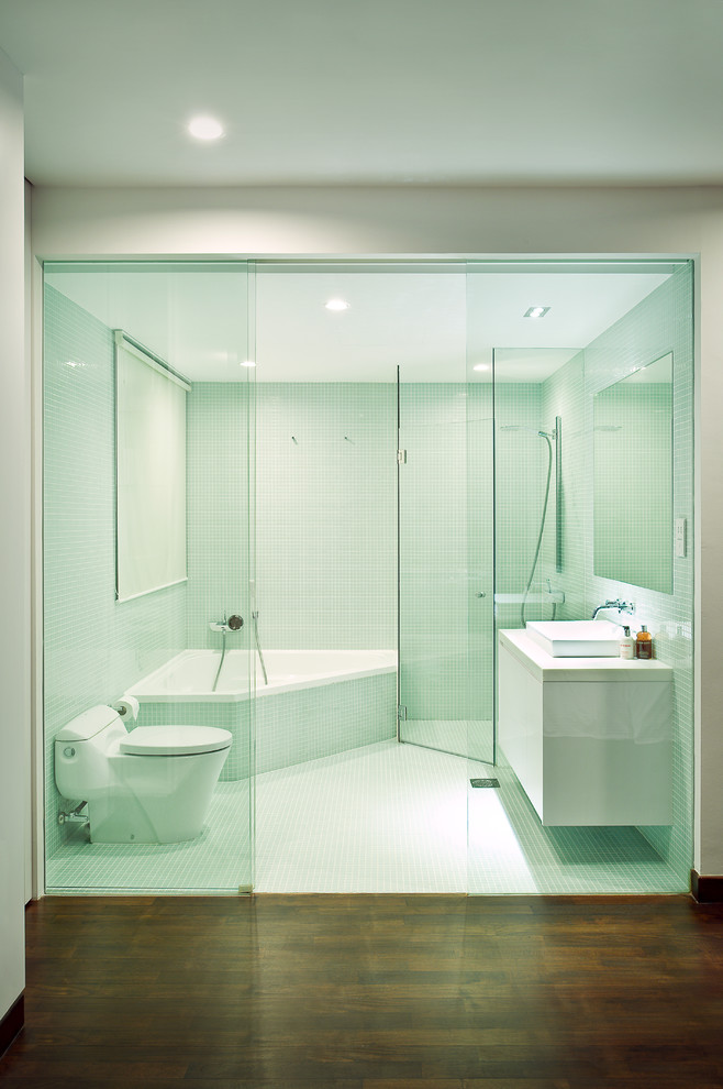 Modelo de cuarto de baño contemporáneo con bañera esquinera, ducha esquinera, lavabo sobreencimera y suelo marrón