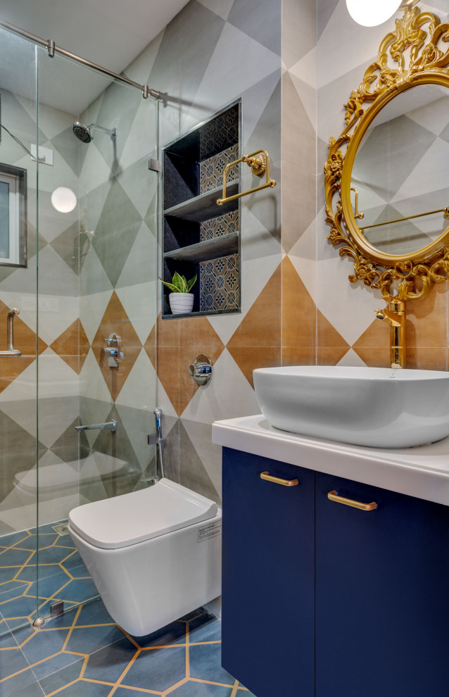 Cette image montre une salle de bain design de taille moyenne avec un placard à porte plane, des portes de placard bleues, WC suspendus, un carrelage beige, un carrelage gris, des carreaux de porcelaine, une vasque, un sol bleu, une cabine de douche à porte battante, un plan de toilette beige, une niche, meuble simple vasque et meuble-lavabo encastré.