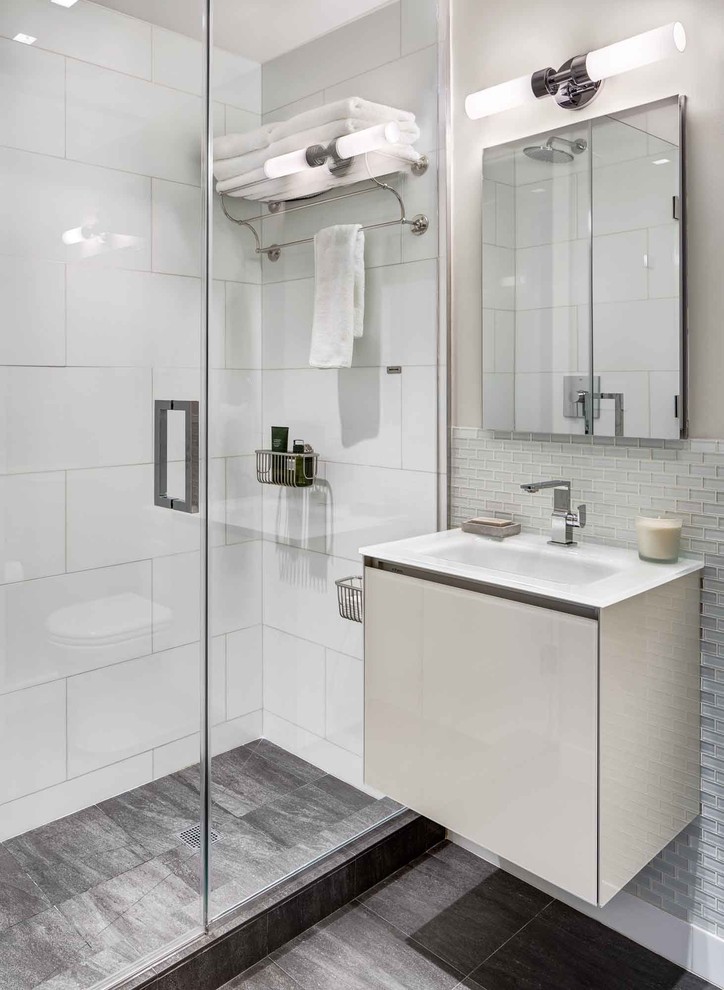 Пример оригинального дизайна: ванная комната среднего размера в современном стиле с душем в нише, душевой кабиной, подвесной раковиной, плоскими фасадами, стеклянной плиткой, бежевыми стенами, полом из керамогранита, серым полом и душем с распашными дверями