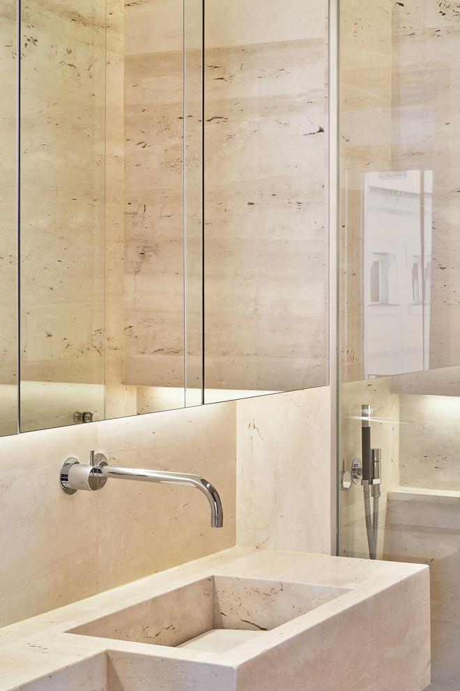 Ispirazione per una stanza da bagno padronale minimalista con doccia alcova, piastrelle in travertino, pavimento in travertino, lavabo integrato e porta doccia a battente