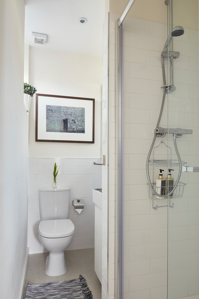 Inspiration pour une petite salle de bain principale nordique avec un placard à porte vitrée, des portes de placard blanches, une douche ouverte, WC à poser, un mur blanc, un sol en vinyl, un lavabo suspendu, un sol blanc et une cabine de douche à porte battante.