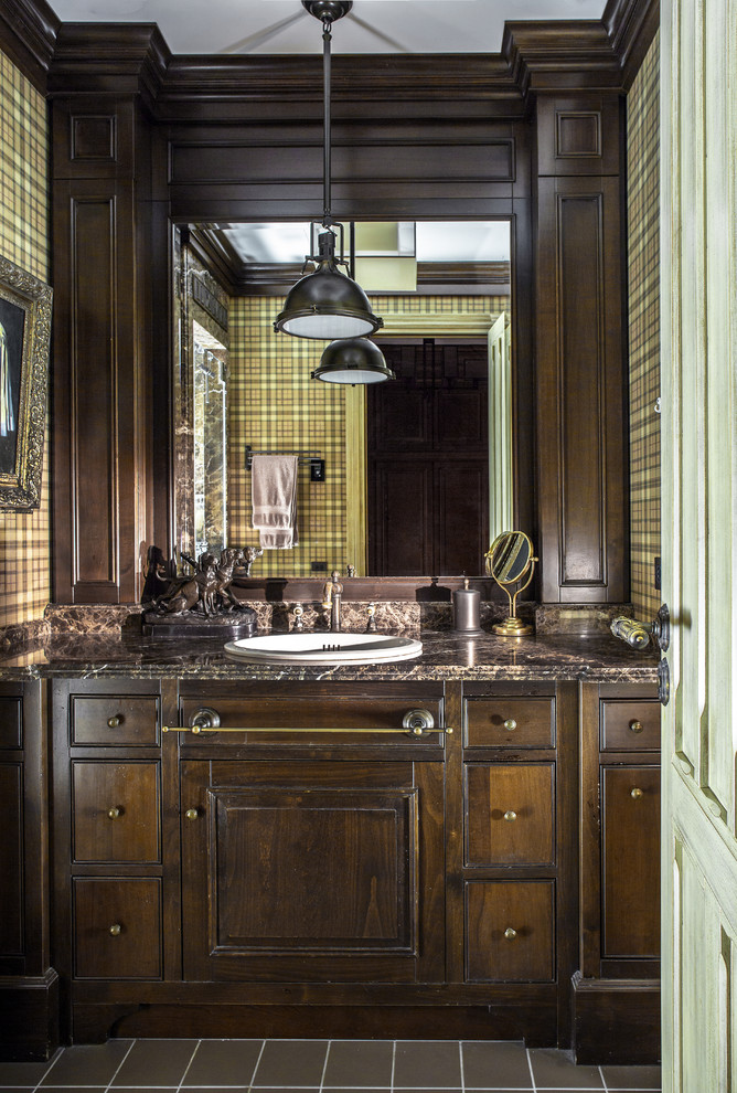 Cette image montre une salle de bain victorienne en bois foncé avec un plan de toilette marron.
