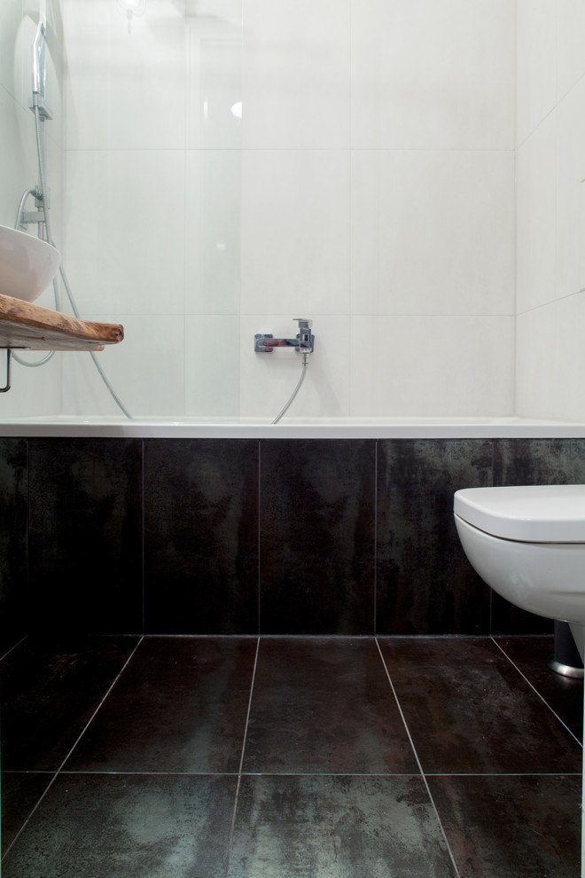Idéer för att renovera ett litet funkis badrum med dusch, med ett väggmonterat handfat, träbänkskiva, ett platsbyggt badkar, en vägghängd toalettstol, svart kakel, stenkakel, vita väggar och kalkstensgolv