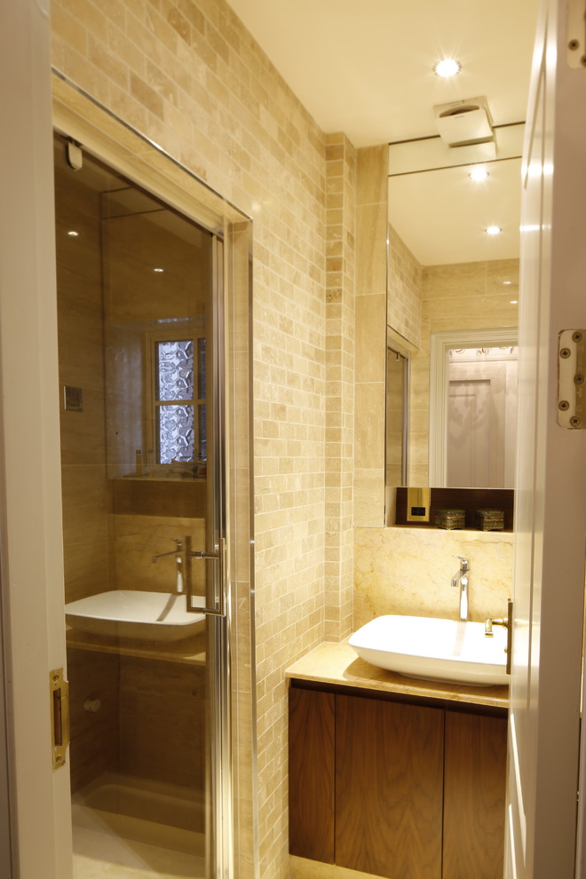 Design ideas for a small classic family bathroom in London with flat-panel cabinets, dark wood cabinets, an alcove shower, a wall mounted toilet, beige tiles, ceramic tiles, beige walls, ceramic flooring, a vessel sink and marble worktops.