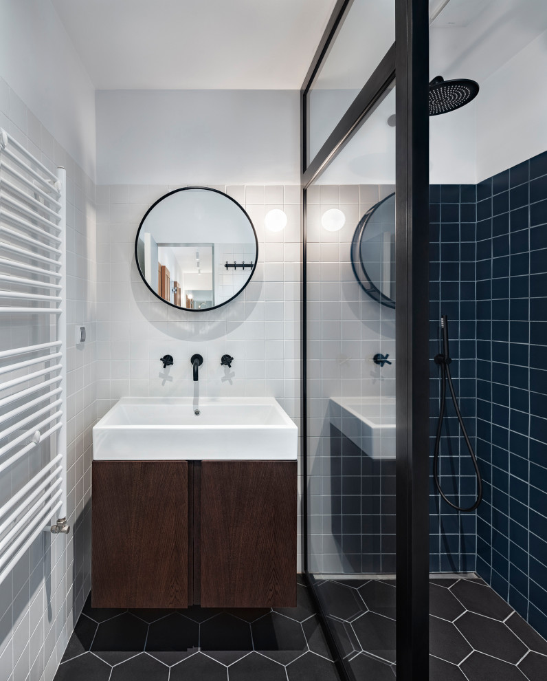 This is an example of a medium sized contemporary shower room bathroom in London with flat-panel cabinets, brown cabinets, an alcove shower, blue tiles, porcelain tiles, white walls, porcelain flooring, an integrated sink, black floors and white worktops.