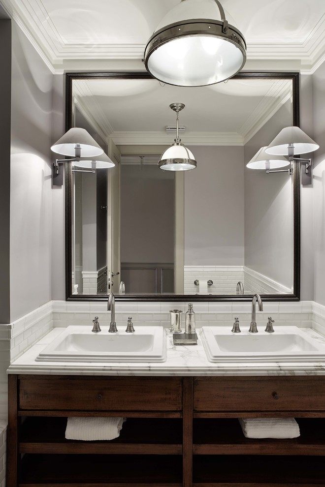 Imagen de cuarto de baño contemporáneo con armarios con paneles lisos, puertas de armario de madera en tonos medios, paredes grises y lavabo encastrado
