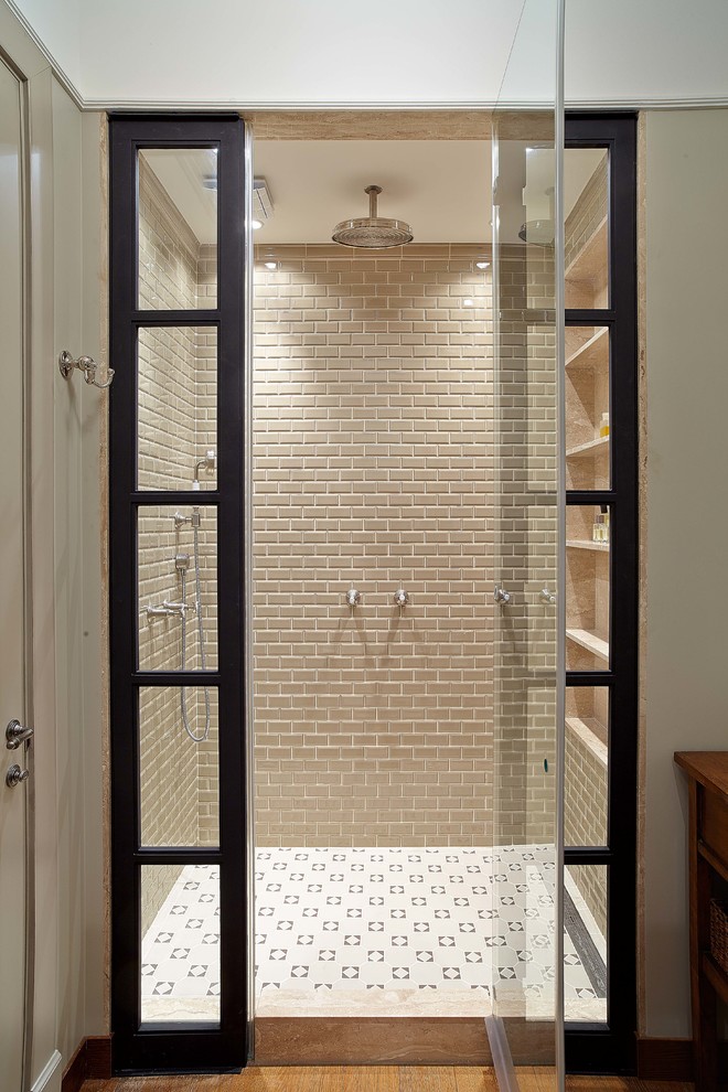Immagine di una stanza da bagno design con doccia alcova, pareti beige e porta doccia a battente