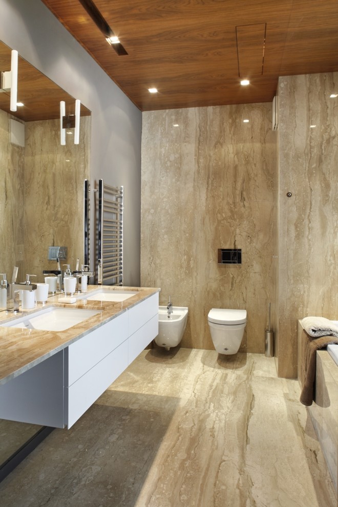 Trendy marble tile bathroom photo with marble countertops and a wall-mount toilet