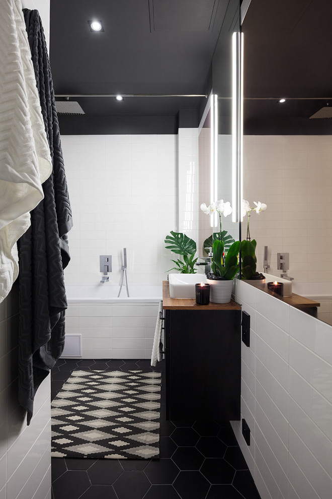 Idéer för att renovera ett litet amerikanskt en-suite badrum, med möbel-liknande, svarta skåp, ett undermonterat badkar, en dusch/badkar-kombination, en vägghängd toalettstol, svart och vit kakel, porslinskakel, grå väggar, klinkergolv i porslin, ett konsol handfat och laminatbänkskiva