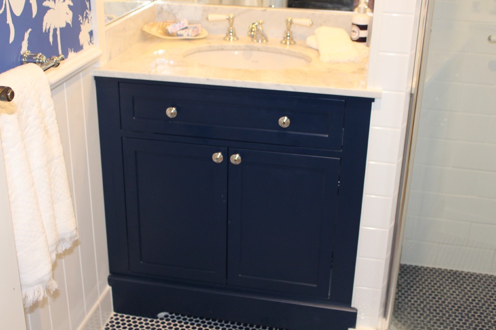 Imagen de cuarto de baño marinero con armarios estilo shaker, puertas de armario azules, ducha esquinera, sanitario de dos piezas, paredes azules, lavabo bajoencimera, encimera de mármol y ducha con puerta con bisagras