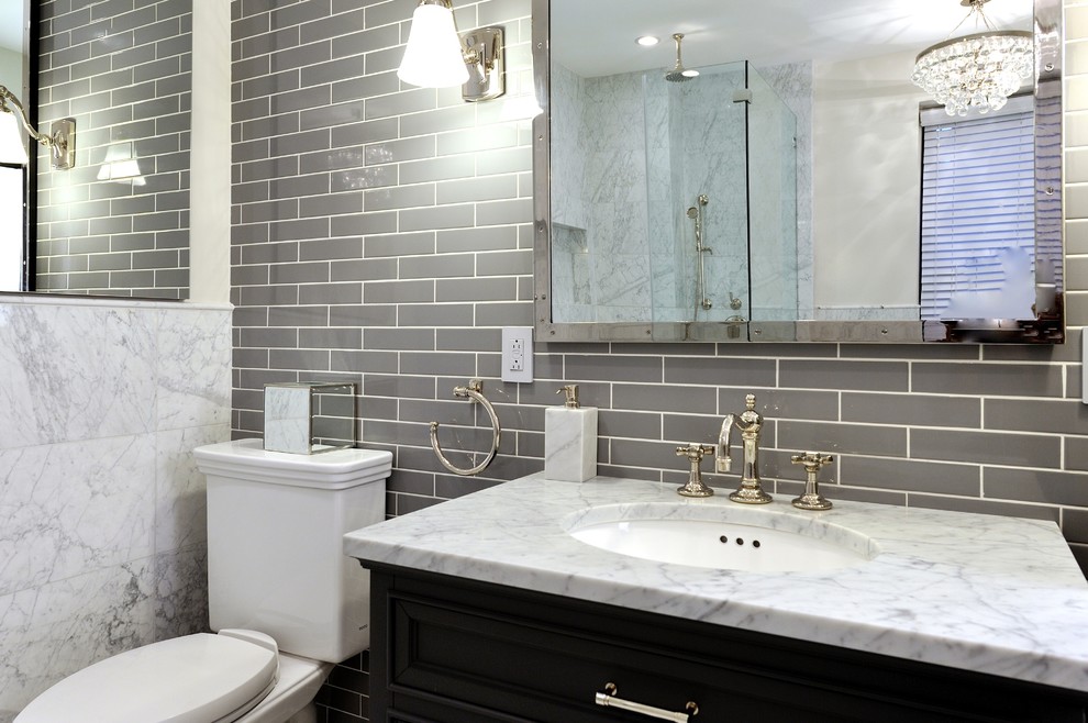 Large trendy gray tile marble floor bathroom photo in New York with an integrated sink, raised-panel cabinets, dark wood cabinets, wood countertops, a one-piece toilet and white walls