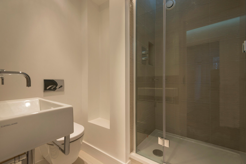 Inspiration för små moderna badrum för barn, med ett väggmonterat handfat, en dusch i en alkov, en vägghängd toalettstol, beige kakel, keramikplattor, vita väggar och klinkergolv i keramik