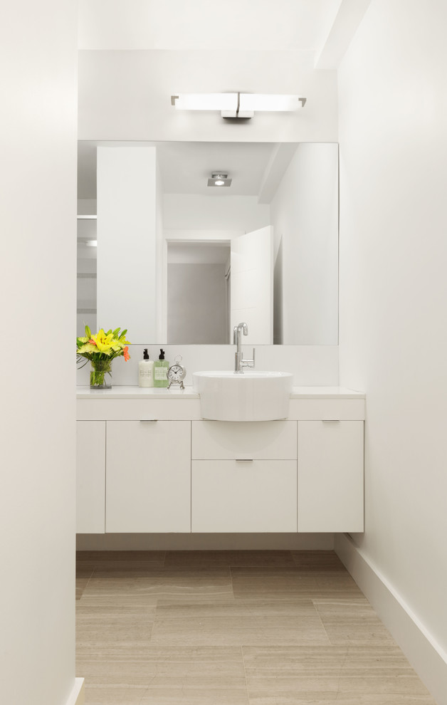 Inspiration for a medium sized traditional ensuite bathroom in New York with flat-panel cabinets, white cabinets, an alcove shower, a one-piece toilet, white tiles, porcelain tiles, white walls, limestone flooring, a vessel sink, engineered stone worktops, a shower curtain and beige floors.