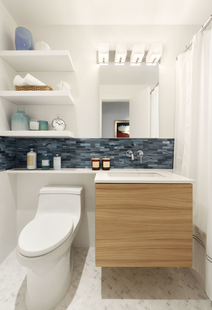 Small classic bathroom in New York with flat-panel cabinets, light wood cabinets, an alcove bath, a shower/bath combination, a one-piece toilet, white tiles, porcelain tiles, white walls, marble flooring, a submerged sink, engineered stone worktops, white floors and a shower curtain.
