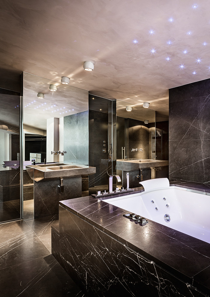 Идея дизайна: большая главная ванная комната в современном стиле с гидромассажной ванной, черной плиткой, плиткой из листового камня, черными стенами, мраморным полом и монолитной раковиной