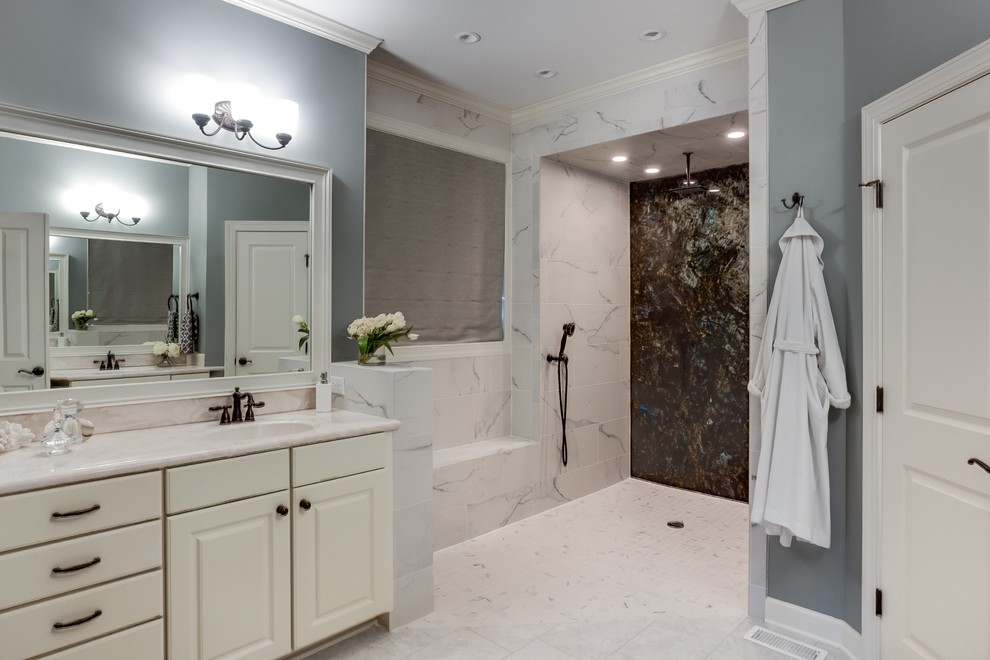Large trendy master white tile and ceramic tile ceramic tile doorless shower photo in Raleigh with raised-panel cabinets, white cabinets, marble countertops, gray walls, a two-piece toilet and an integrated sink