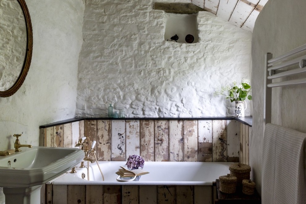 Aménagement d'une salle de bain campagne de taille moyenne avec un mur blanc, un lavabo de ferme et une baignoire posée.