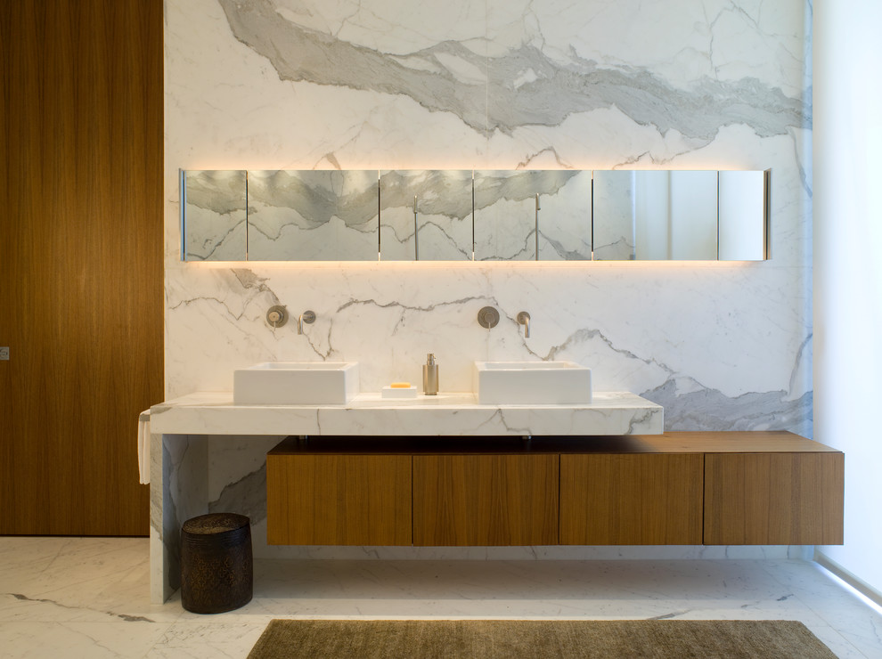 Aménagement d'une salle de bain principale contemporaine en bois brun de taille moyenne avec un placard à porte plane, un carrelage blanc, un mur blanc, une vasque, un sol blanc, un sol en marbre, un plan de toilette en marbre et un plan de toilette gris.