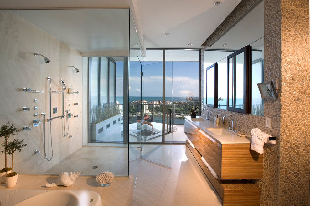 Contemporary bathroom in Miami with a submerged sink, flat-panel cabinets, medium wood cabinets, a built-in shower and beige tiles.