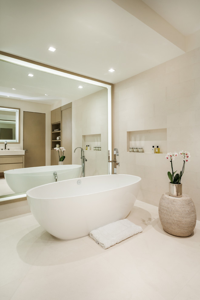 Example of a trendy beige tile freestanding bathtub design in Miami