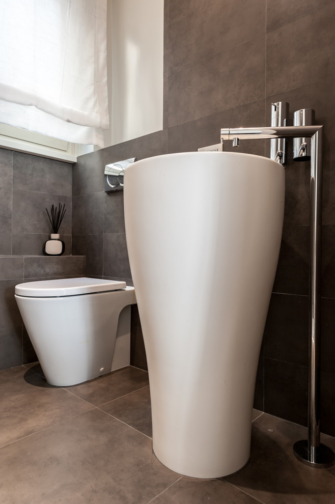 Ispirazione per una stanza da bagno design con WC monopezzo, pareti grigie e pavimento grigio