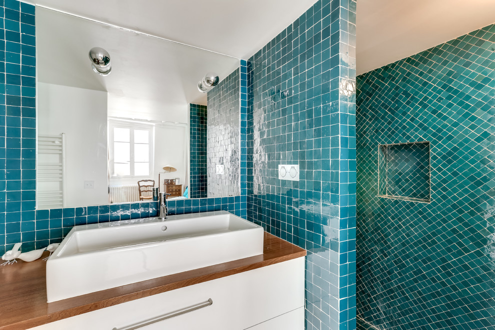 Idéer för mellanstora brunt badrum med dusch, med öppna hyllor, en öppen dusch, grön kakel, blå kakel, mosaik, gröna väggar, mosaikgolv, grönt golv, med dusch som är öppen, vita skåp, ett konsol handfat och träbänkskiva